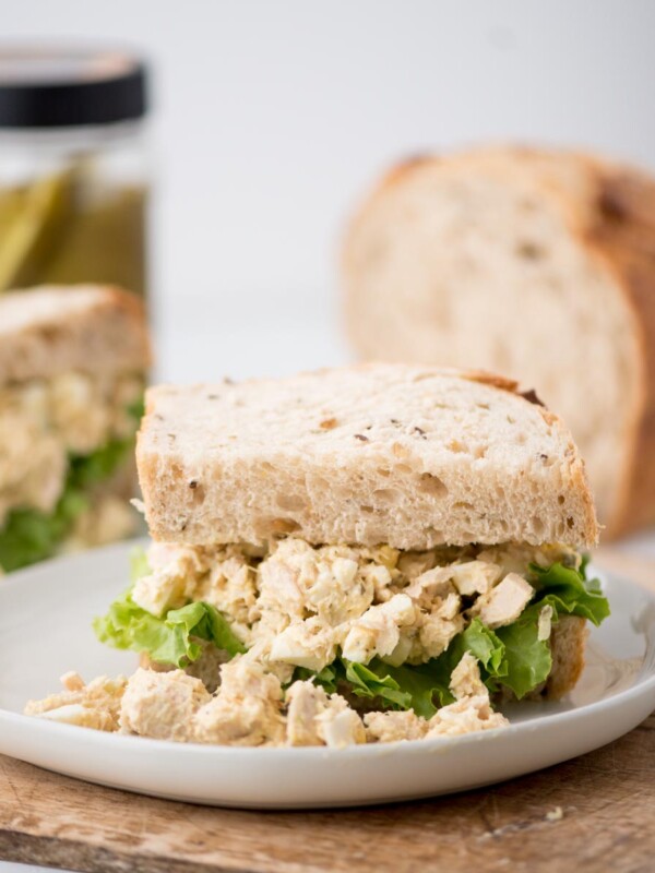 An overflowing tuna salad sandwich on wheat bread.