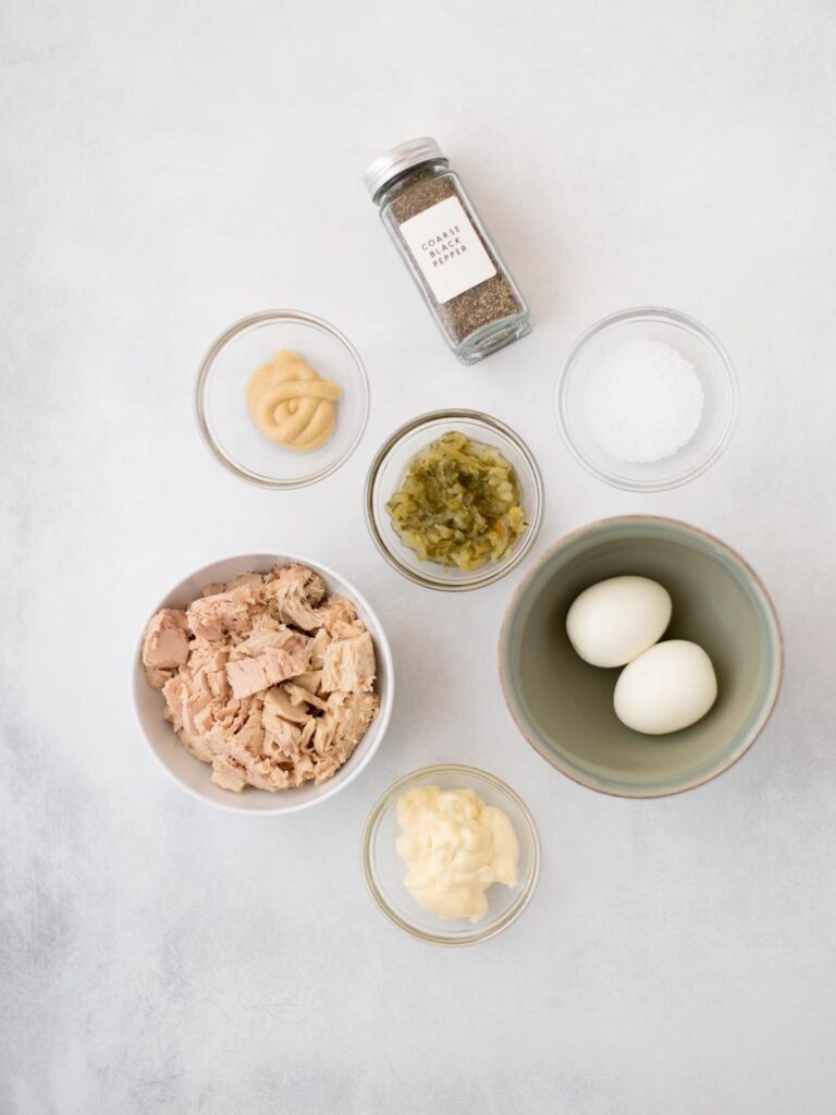 Ingredients measured in small bowls to prepare tuna salad.