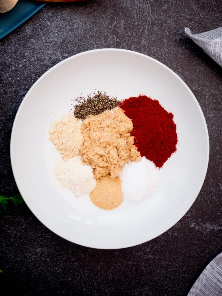 Glass bowl filled with measured ingredients needed to make chicken seasoning