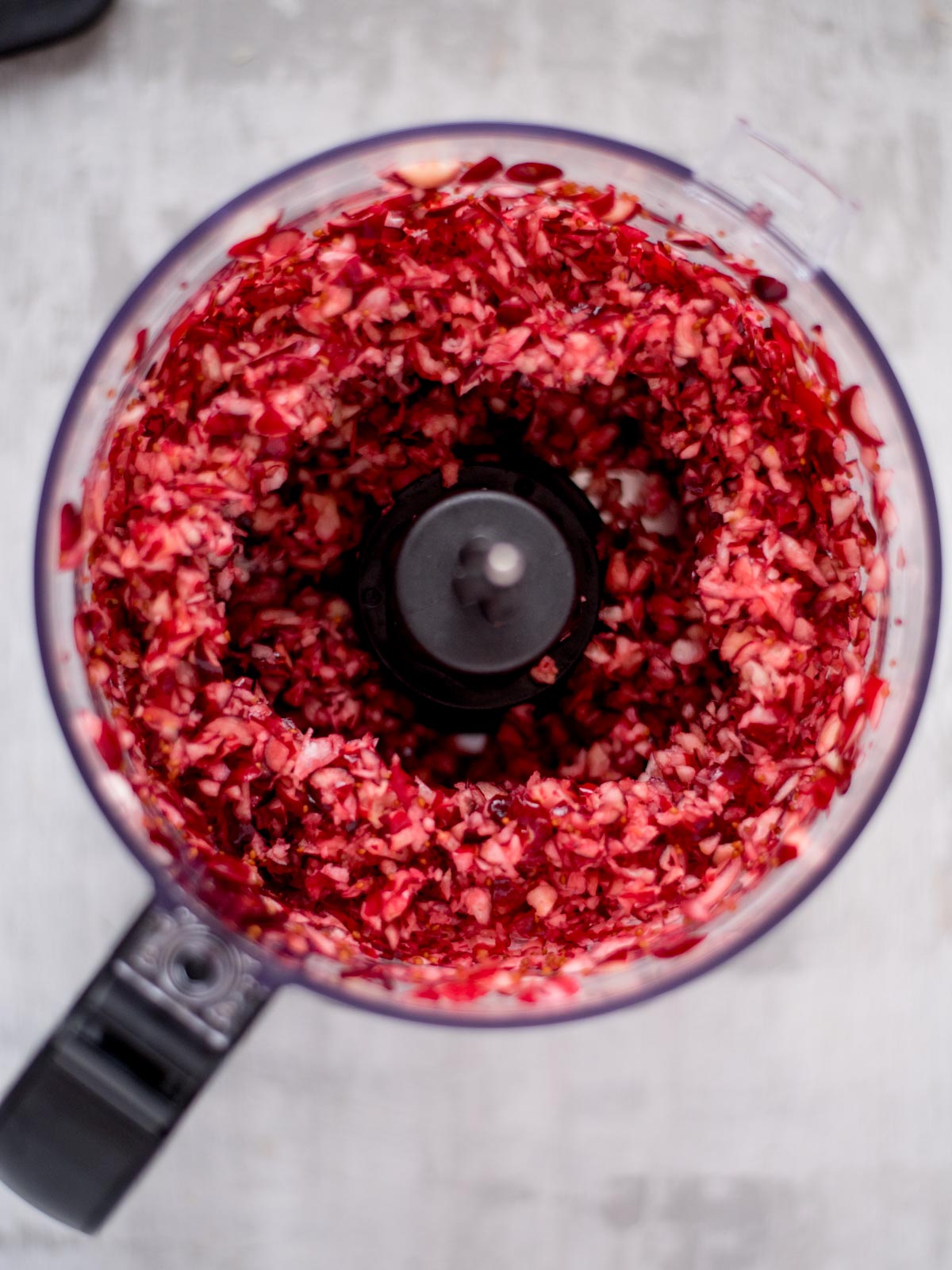 Food processer filled with diced cranberries.
