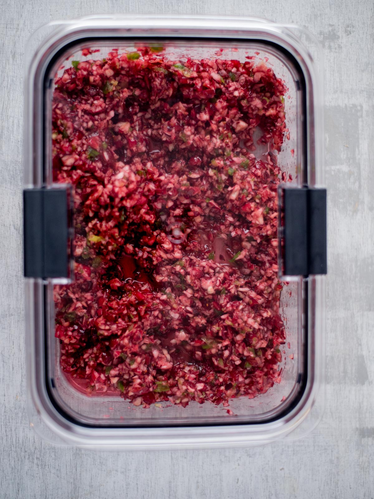 Cranberry jalapeno salsa in an airtight container.
