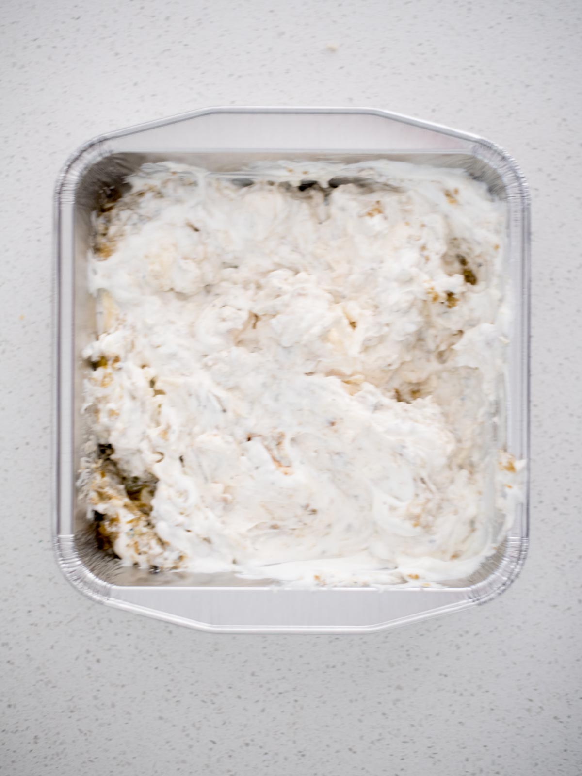 queso blanco ingredients mixed together in an aluminum pan