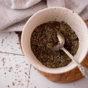 Spoon laying in a bowl of homemade italian seasoning.