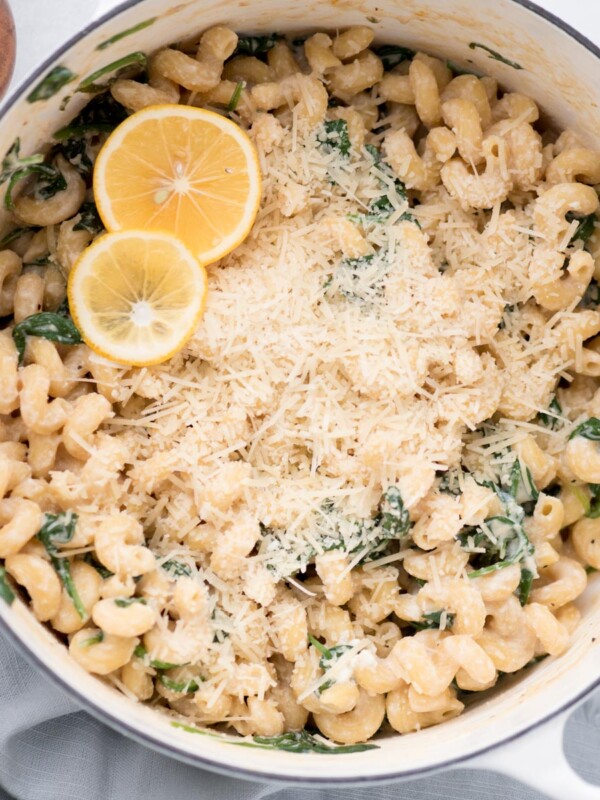 Lemon rounds placed over parmesan topped lemon ricotta pasta in a dutch oven.