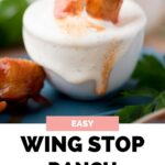 Wing stop ranch in a small bowl with a drummette being dipped into it.