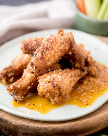garlic parmesan chicken wings stacked on a light blue plate
