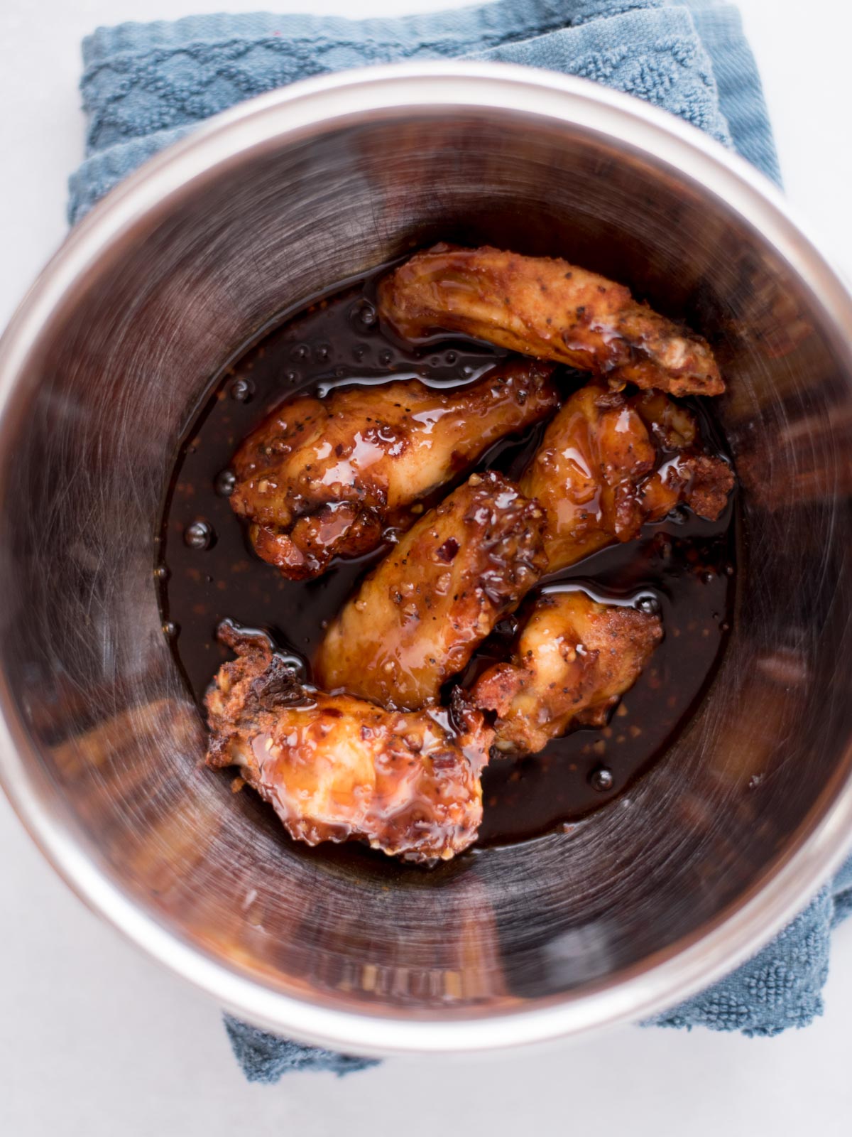 wings in a mixing bowl tossed with honey garlic sauce