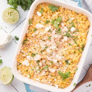 Baking dish of mexican corn casserole with cotija cheese and cilantro on top.