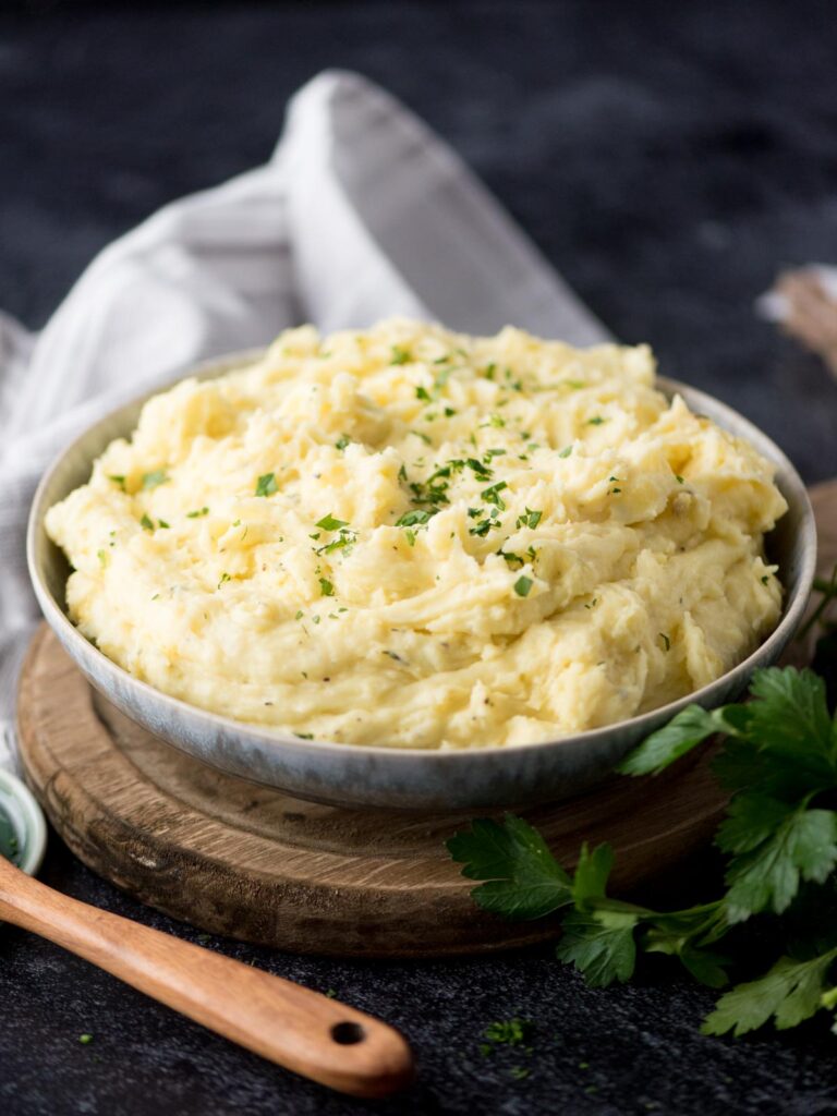 Parsley garnished next to a bowl of boursin mashed potatoes.