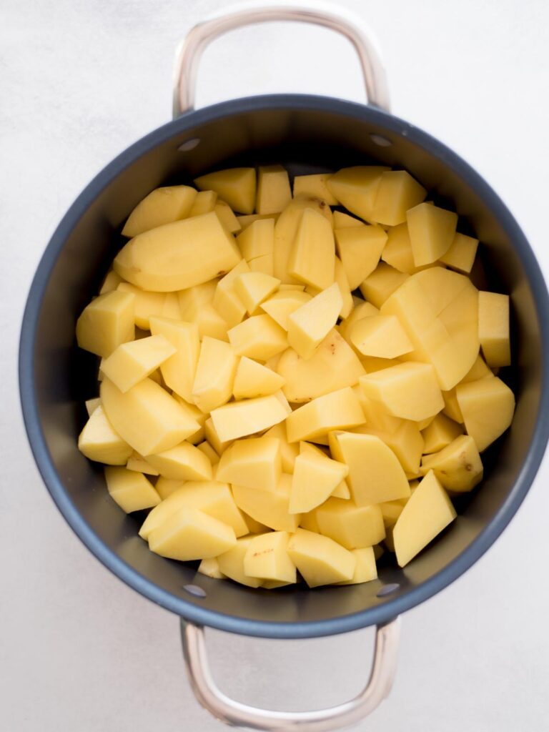 Peeled and chopped potatoes added to a large pot.