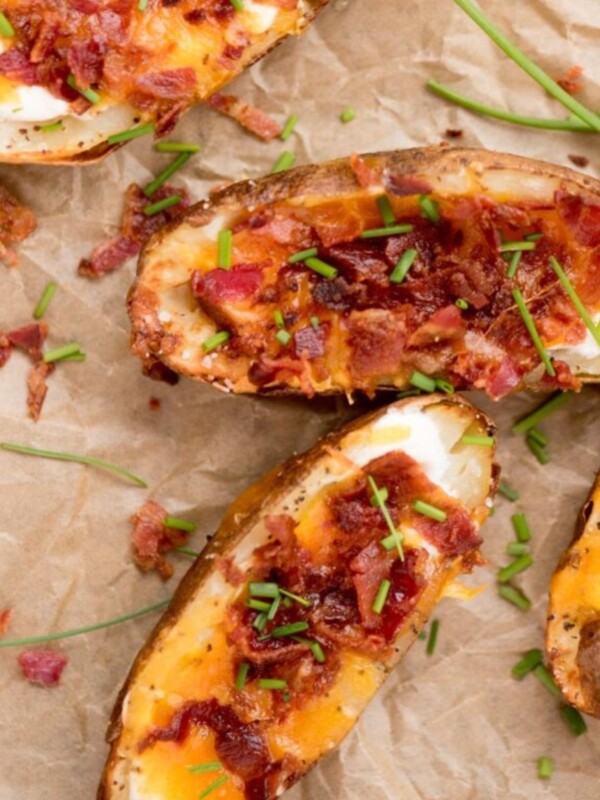 Air fryer loaded potatoes with sour cream, bacon and cheese, garnished with chopped chives ready to serve.