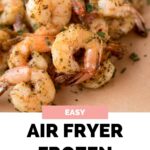pinterest graphic with text reading easy air fryer frozen shrimp with an image of cooked shrimp on a parchment lined plate
