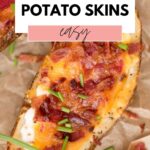 Top view of a loaded potato skin with chopped chives garnished on top and text overlay air fryer potato skins, easy.