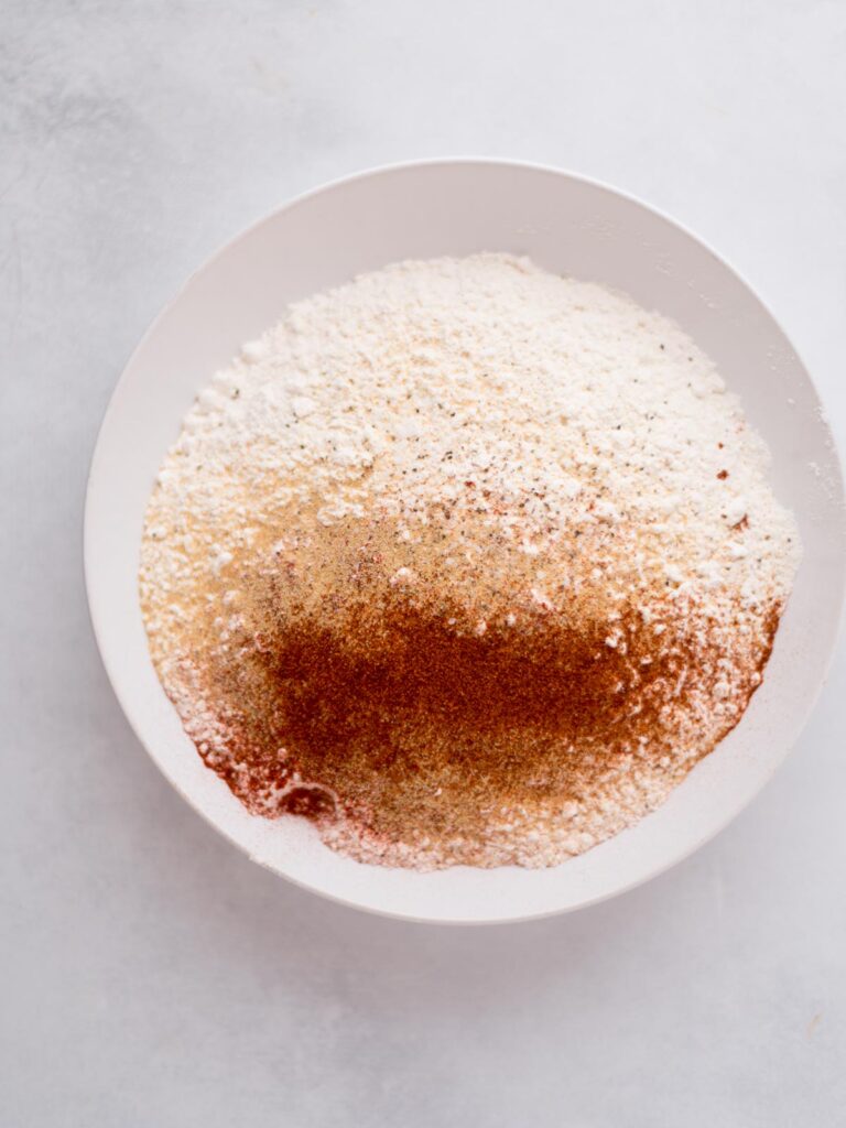 Flour and seasonings combined in a bowl to use as breading on the chicken.