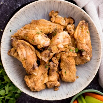 Bowl full of seasoned cajun chicken wings ready to serve.
