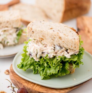 Half chicken salad with lettuce sandwich on a small plate.