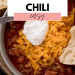 pinterest image that says brisket chili easy on overlaid on a bowl of chili topped with sour cream and shredded cheese