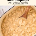 A wooden spoon rests in a pot of creamy chicken and dumplings with biscuits.