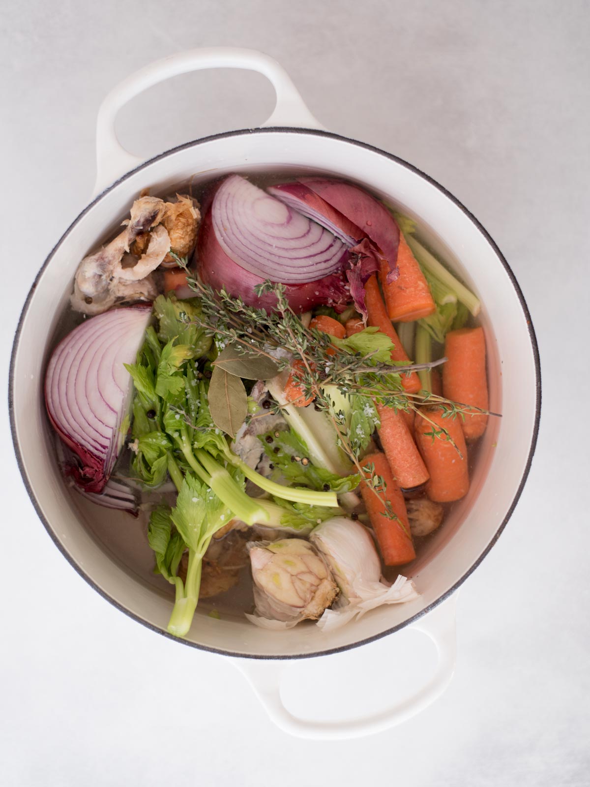 chicken scraps, vegetables, water, and herbs in a dutch oven