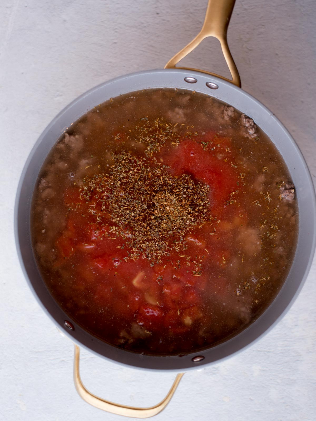 tomato sauce, water, bouillon, and seasoning added to the cooked ground beef