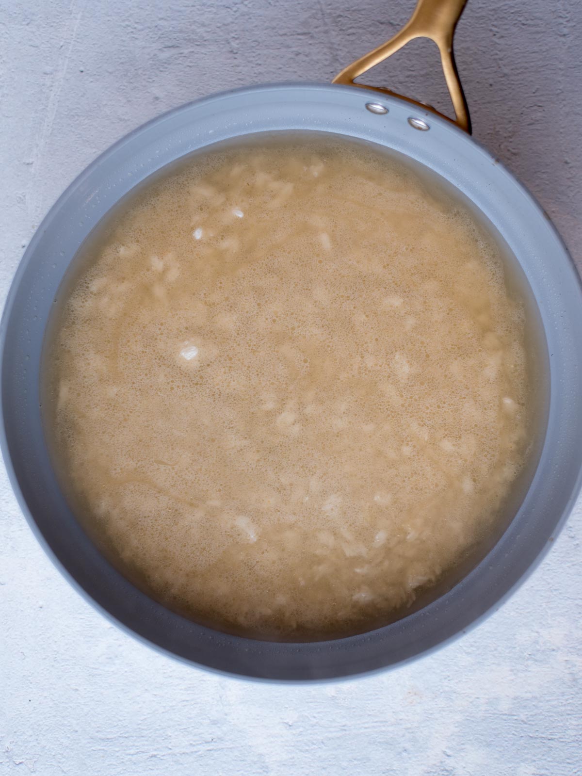 broth in a skillet with the rice and lime juice