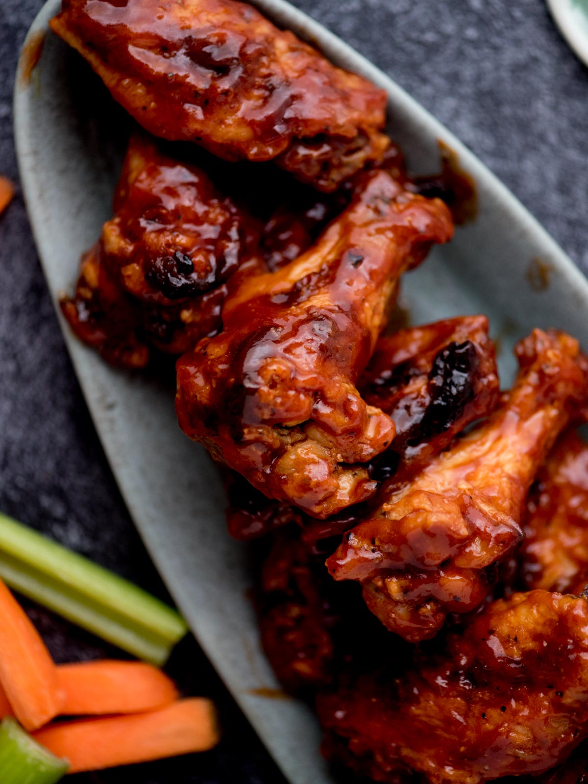 Saucy bbq chicken wings served on an oval platter.