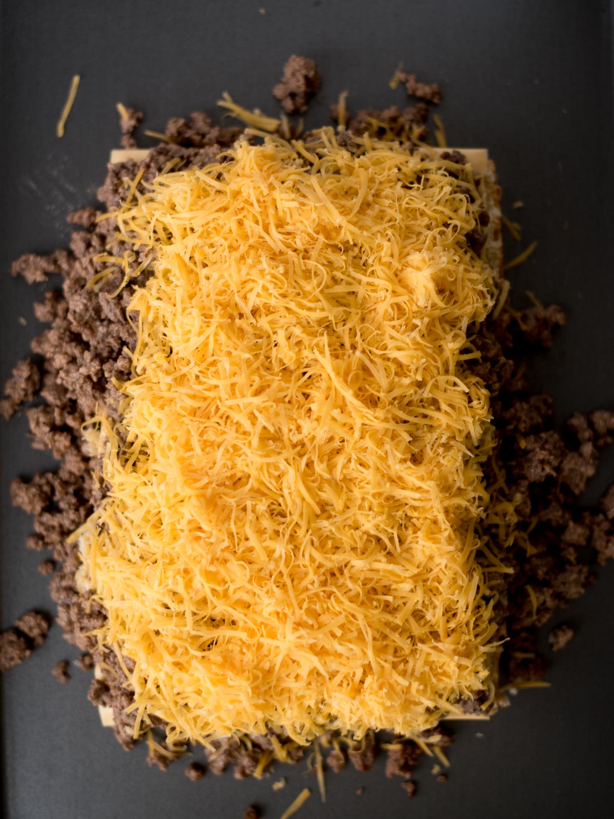 grated cheese on top of the ground beef mixture