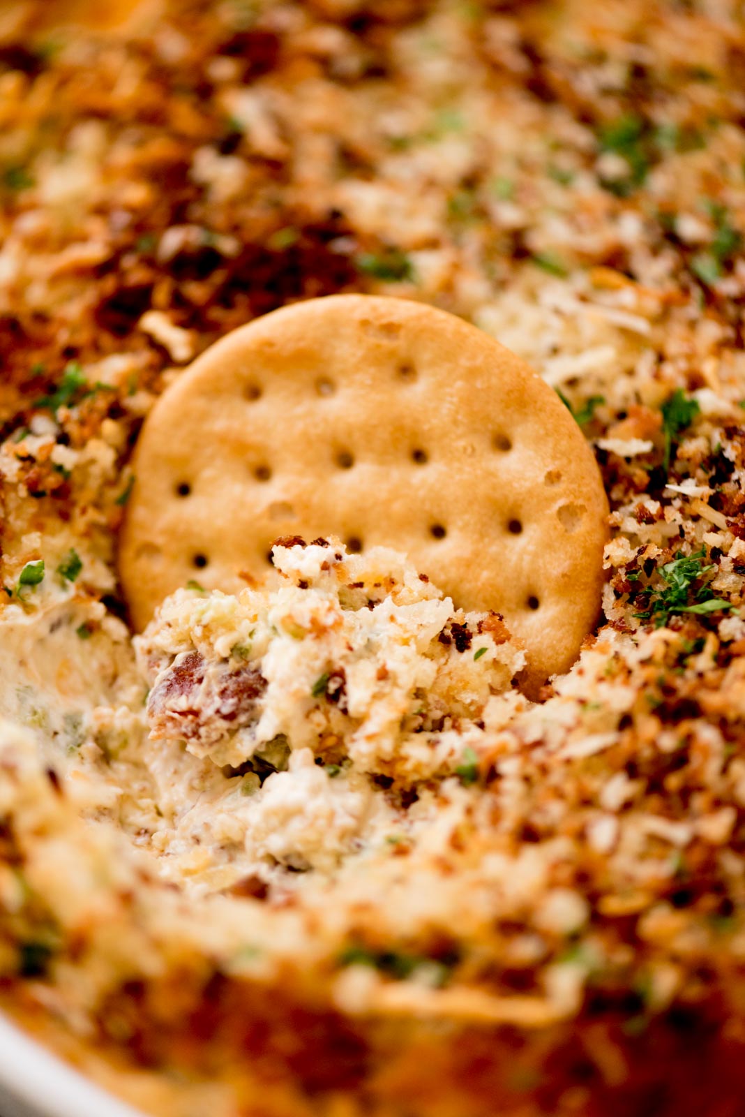 jalapeno popper dip being scooped with a cracker