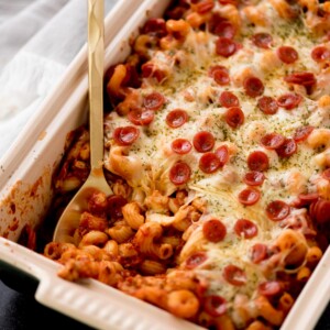 pizza casserole in a baking dish being scooped out with a serving utensil