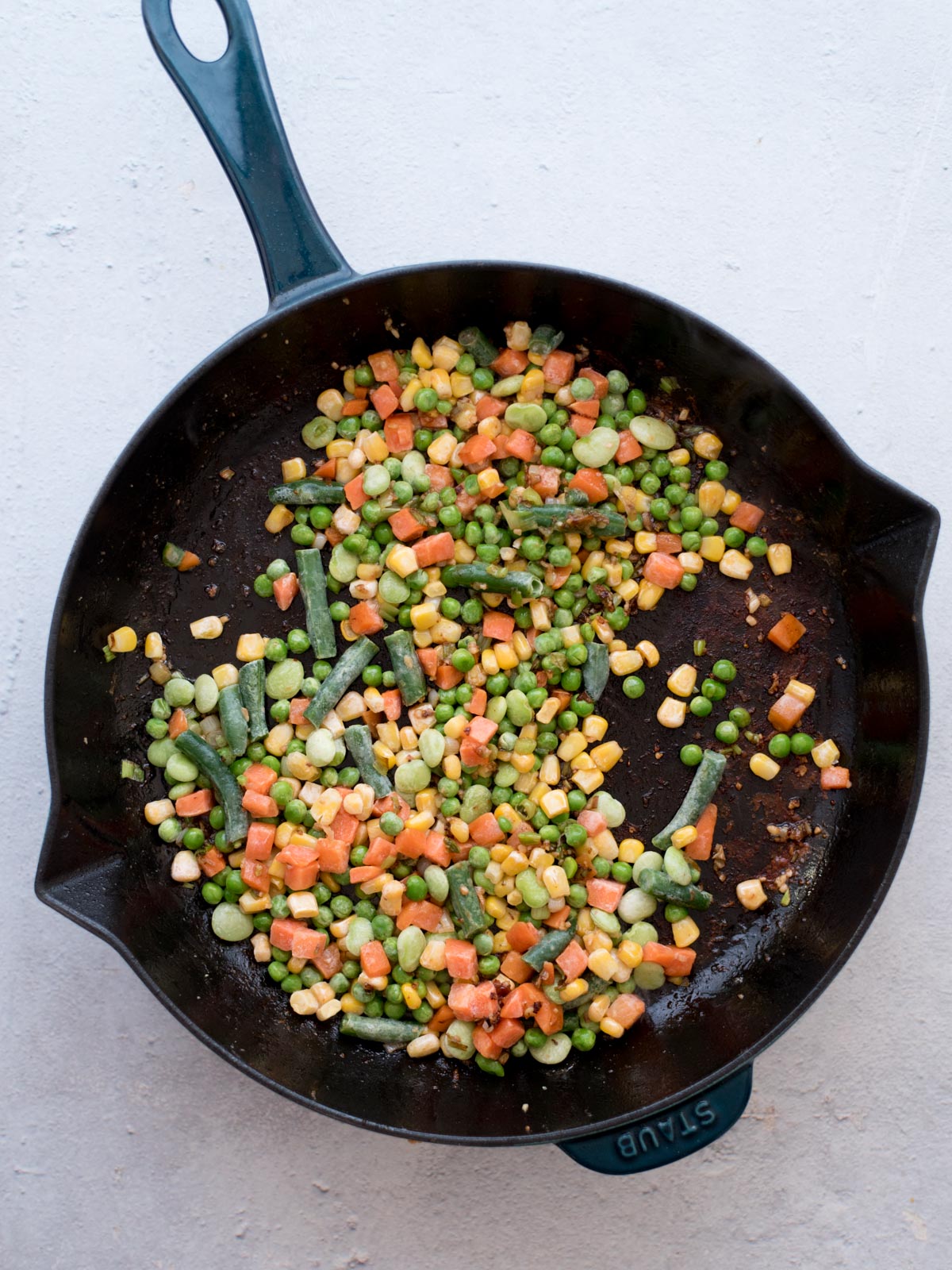 vegetables, garlic, and green onions sautéing in a skillet