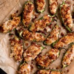 air fryer jalapeno poppers on a parchment paper sitting on top of a bread board