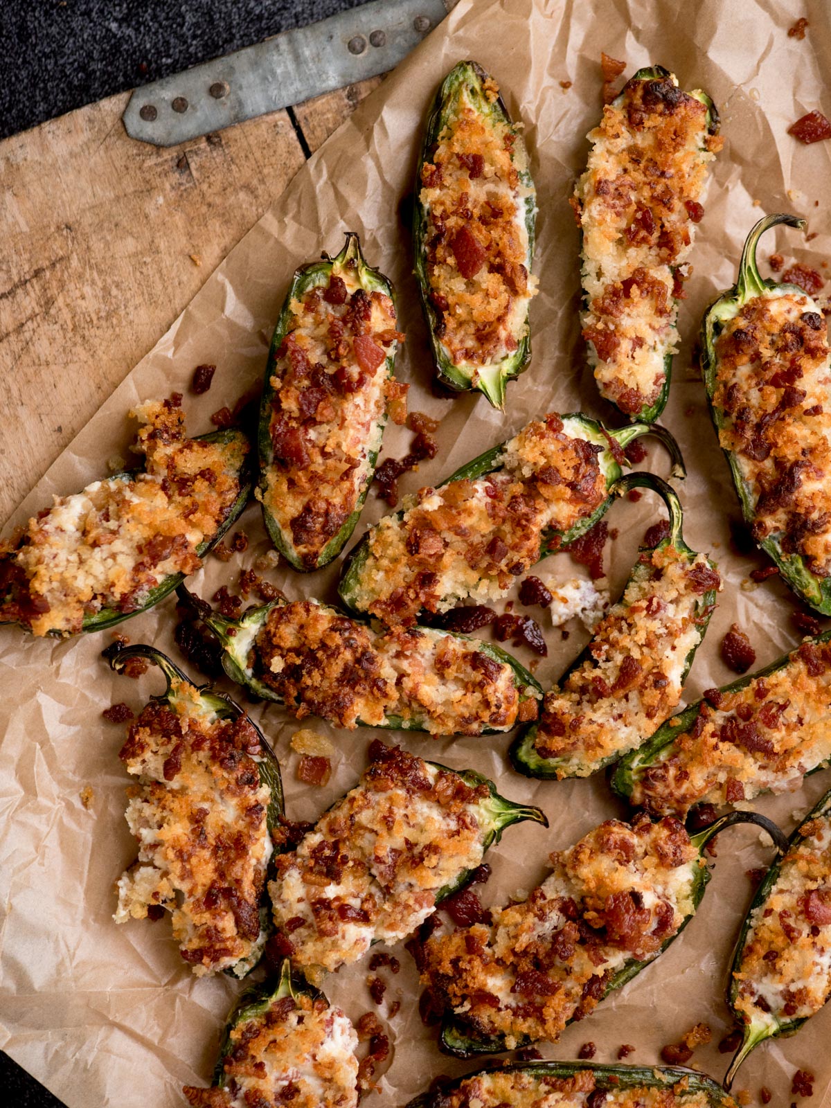 air fryer jalapeno poppers on a parchment paper sitting on top of a bread board