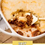A casserole dish with a serving scooped out, revealing a sloppy joe filling beneath a golden crust. A spoon rests in the dish. Text above reads sweetlysplendid.com and below reads Easy Sloppy Joe Casserole.