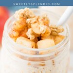 A jar of apple cinnamon overnight oats is topped with diced apples and granola, with a white spoon inside. Blue banner above reads apple cinnamon OVERNIGHT OATS and sweetlysplendid.com.