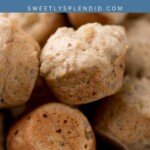 A close-up of freshly baked banana nut muffins stacked on a cooling rack, with a blue banner above displaying the text banana nut muffins and sweetlysplendid.com.