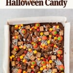 Brownie tray topped with Halloween candies including candy corn, pumpkin-shaped sweets, and chocolate bars.