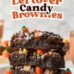 A stack of three brownies topped with chocolate drizzle, candy corn, and pumpkin-shaped candies, with text reading Easy Leftover Candy Brownies at the top.
