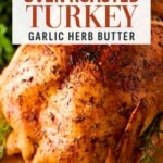 Roasted turkey with garlic herb butter, with text overlay reading: Juicy Oven Roasted Turkey Garlic Herb Butter.