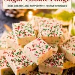 A stack of white chocolate sugar cookie fudge squares topped with red, white, and green sprinkles.